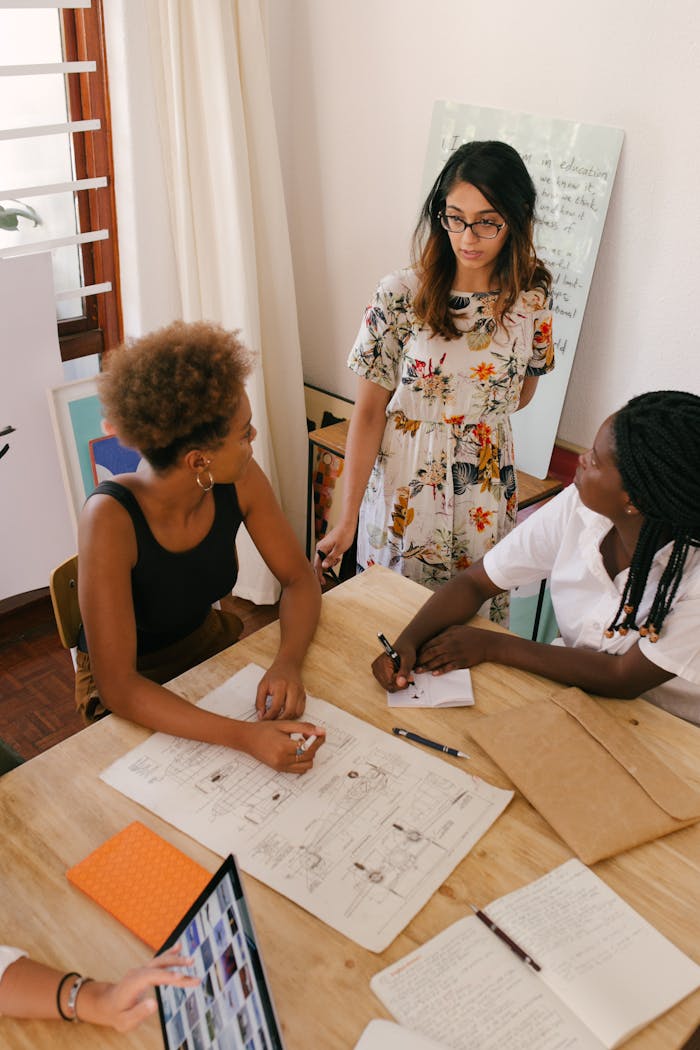 hero-img Diverse team of women brainstorming in a modern office setting.
